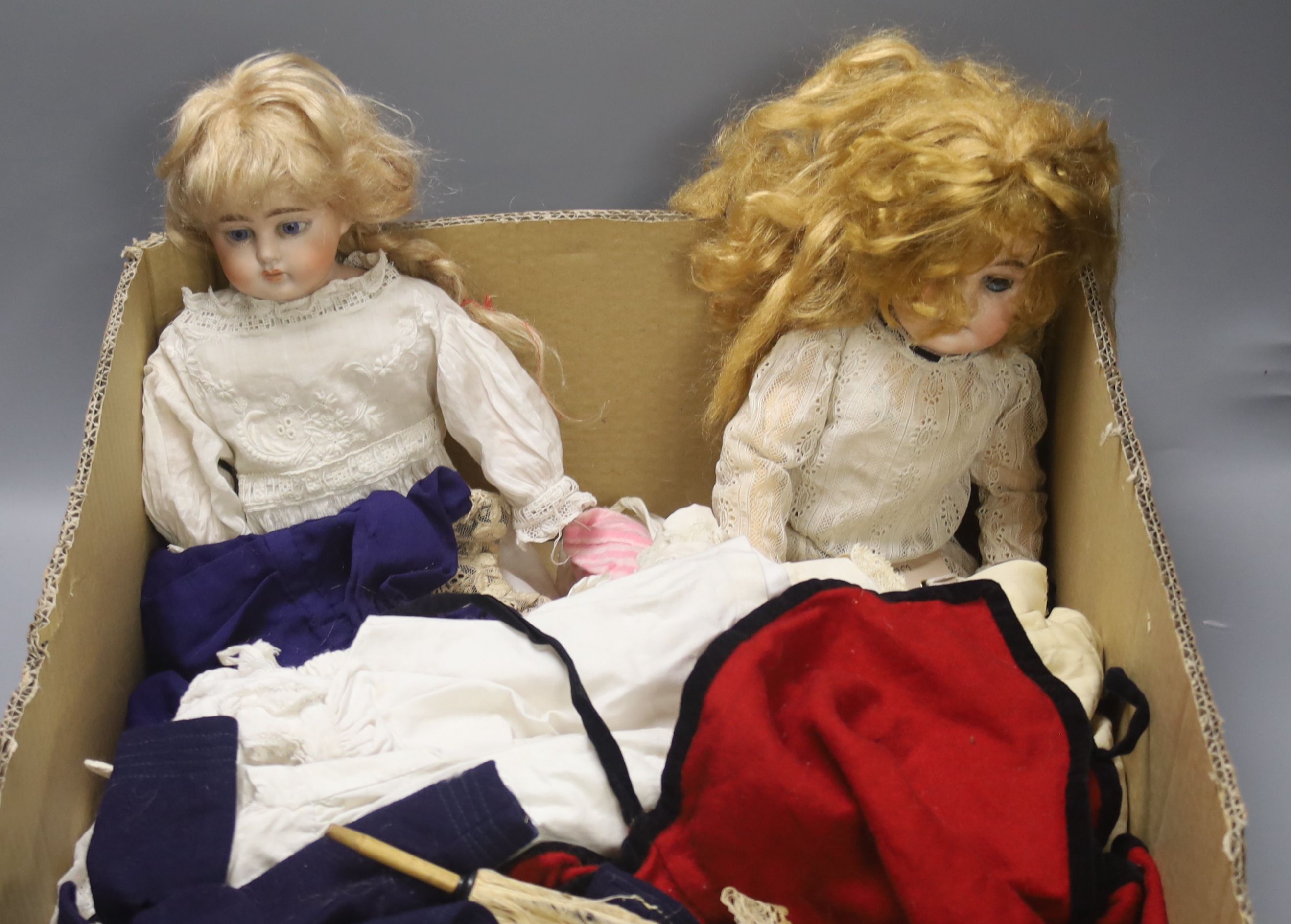 An Armand Marseille doll, an Ernst Heubach doll and a quantity of dolls' clothing, etc.